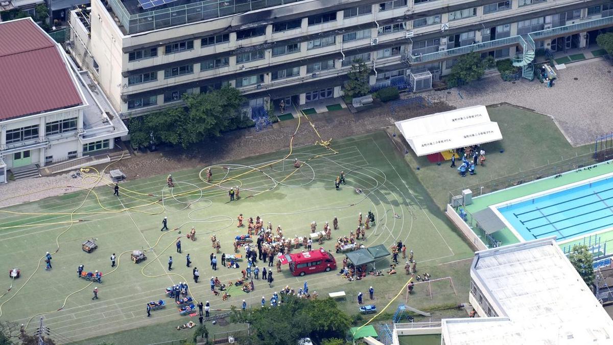 Tokyo elementary school fire traps students; emergency teams rescue children, battle blaze.